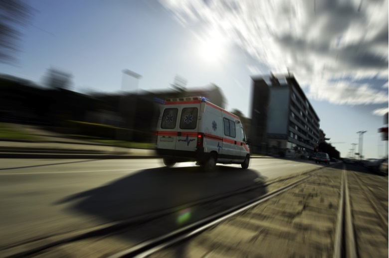 Ambulance driving at high speed on the road.